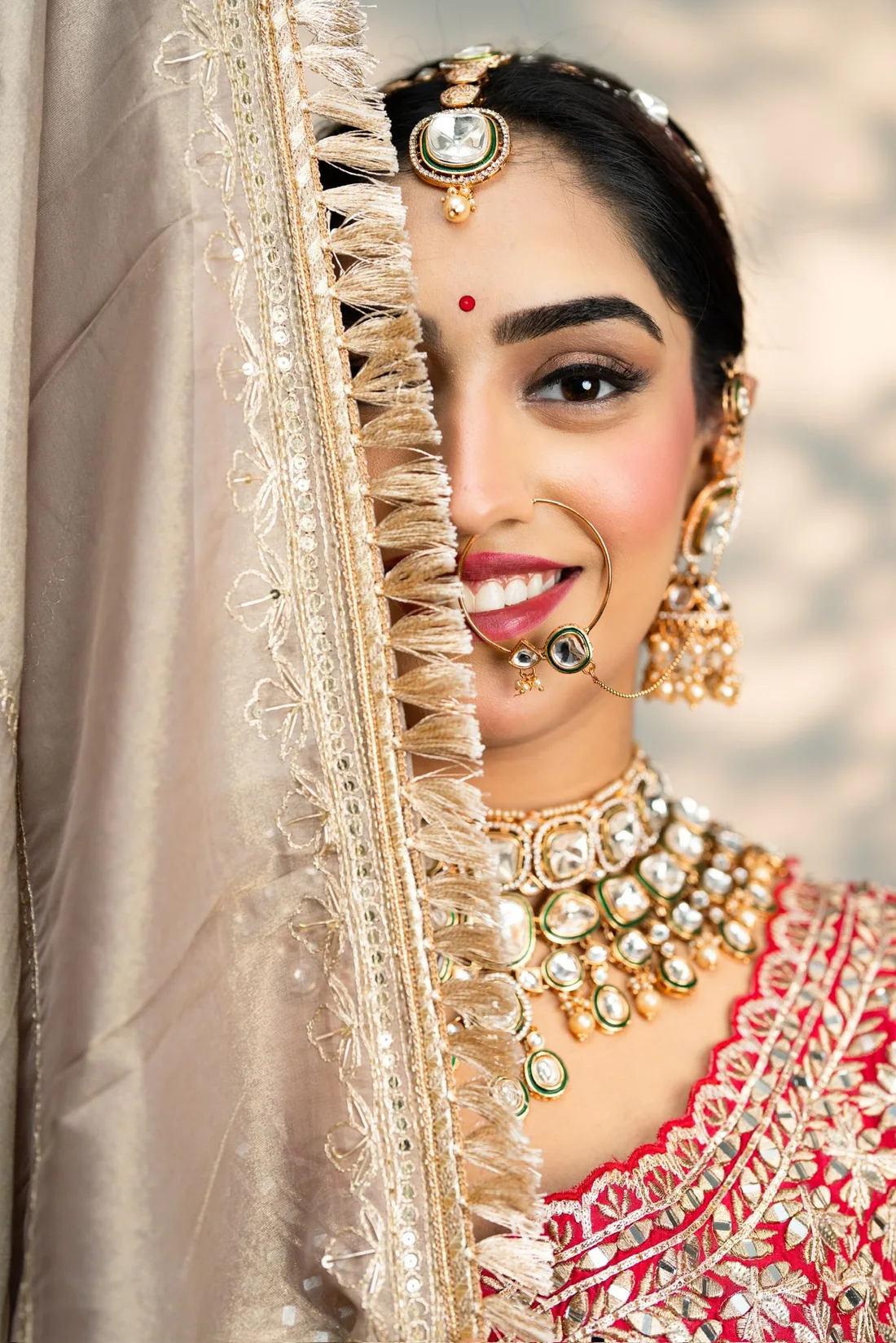 Bridal makeup and jewellery with a red and gold outfit, from the salon gallery