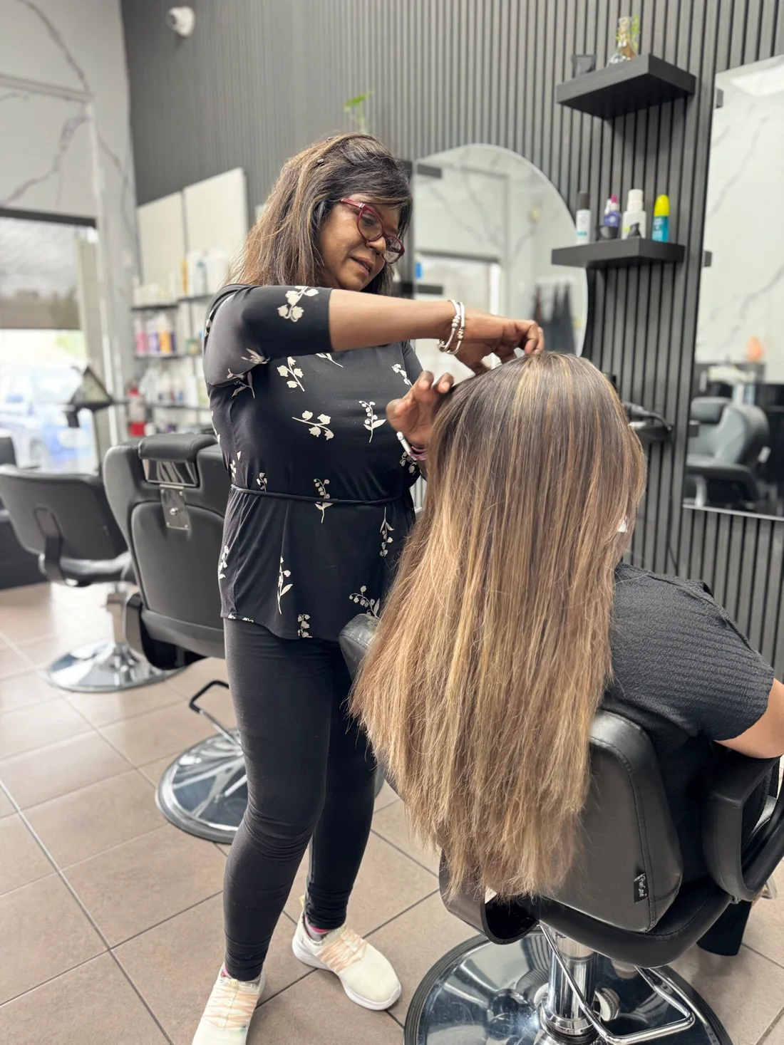A stylist blow-drying long hair in the 7 Heaven salon