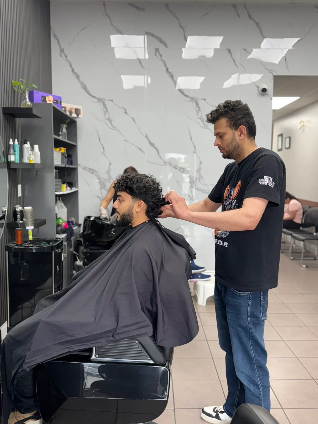 A stylist working on a men’s haircut at 7 Heaven