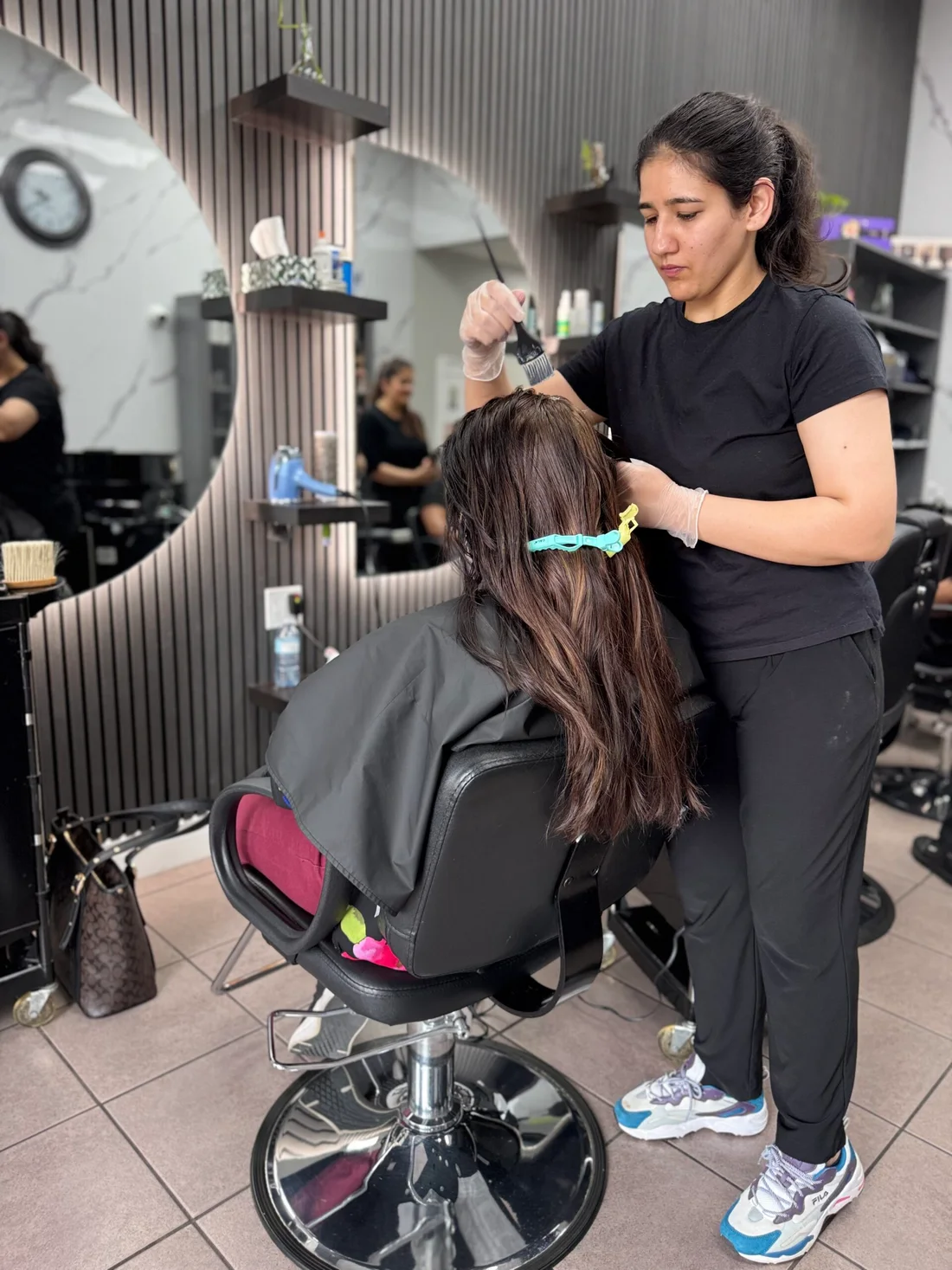 A stylist sectioning a client’s hair at 7 Heaven
