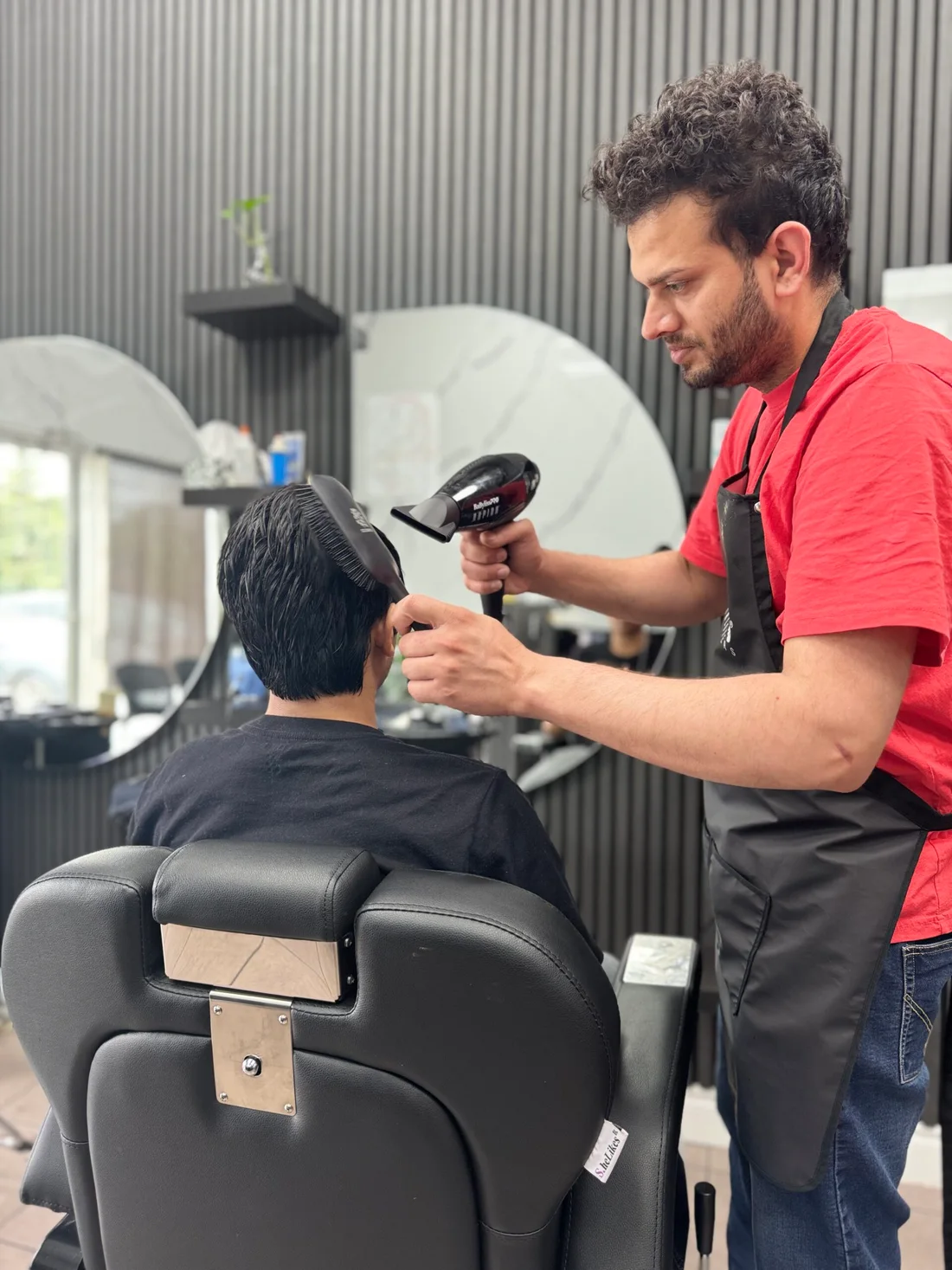 Davinder blow-drying a client’s hair